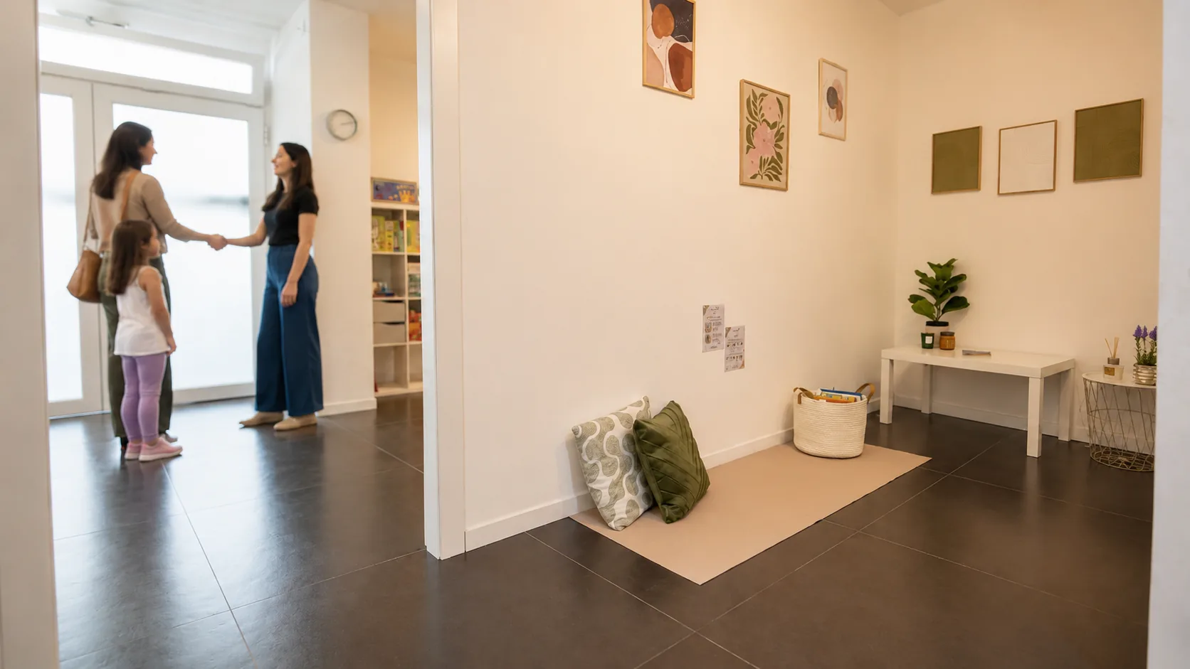 Una mamma con la bambina viene accolta da una professionista all’ingresso del Centro Origami